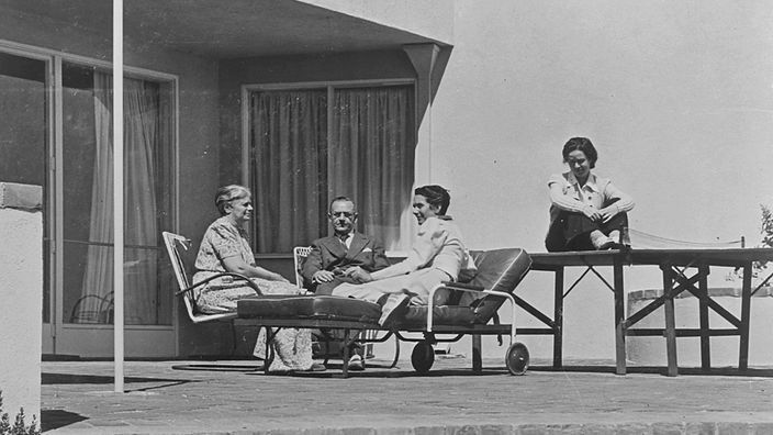 Schwarzweiß-Foto: Thomas, Katia, Erika und Monika Mann beim Relaxen auf der Veranda ihres Hauses in Pacific Palisades