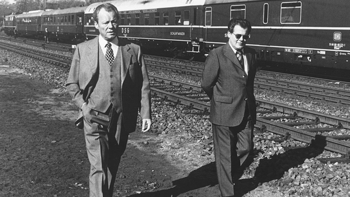 Willy Brandt und Günter Guillaume auf Bahngleisen.