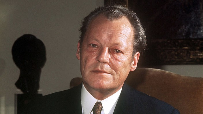 Porträtaufnahme von Willy Brandt an einem Schreibtisch.
