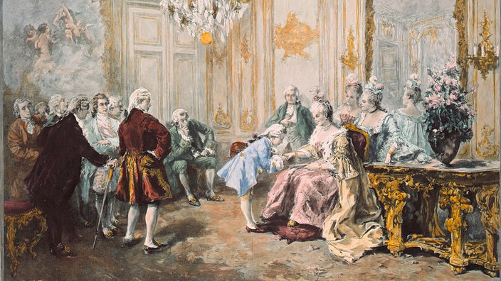 In einem historischen Prunksaal küsst der kleine Mozart die Hand von Madame Pompadour.