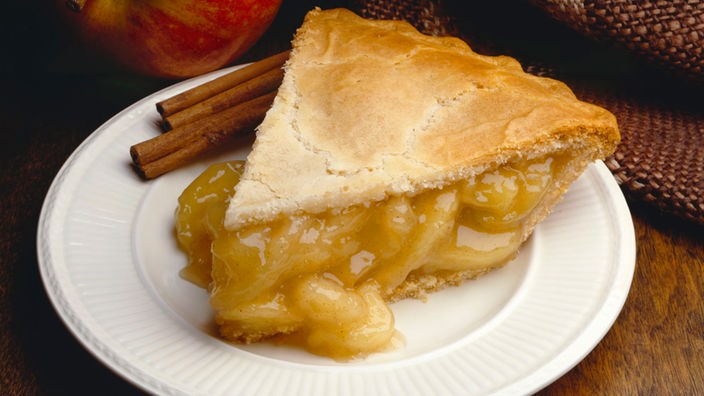 Ein Stück Apple Pie mit Zimtstangen.