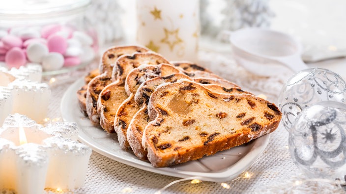 Eine Servierplatte mit aufgeschnittenem Christstollen, rundherum Weihnachtsdekoration | Bildquelle: picture alliance / Zoonar Eine Servierplatte mit aufgeschnittenem Christstollen, rundherum Weihnachtsdekoration