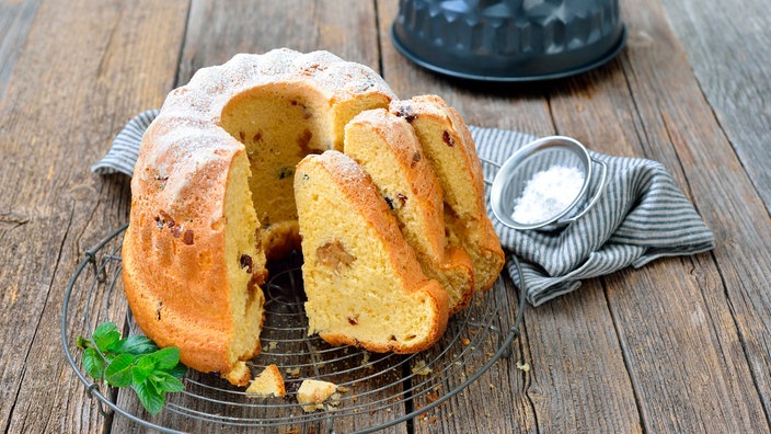 Frischer Hefe-Gugelhupf mit Marzipan und Amaretto-Rosinen auf einem Abkühlring | Bildquelle: picture alliance / Zoonar Frischer Hefe-Gugelhupf mit Marzipan und Amaretto-Rosinen auf einem Abkühlring