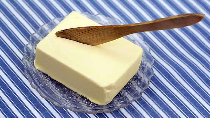Stück Butter mit Holzlöffel