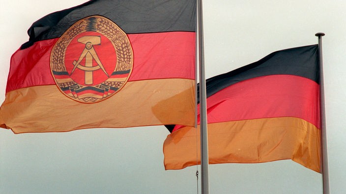 Flaggen der BRD und DDR im Wind.