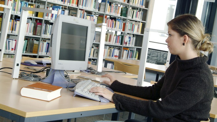 Junge Frau sitzt in einer Bibliothek vor einem Computerbildschirm | Bildquelle: WDR/Mauritius/Hans-Peter Merten Junge Frau sitzt in einer Bibliothek vor einem Computerbildschirm