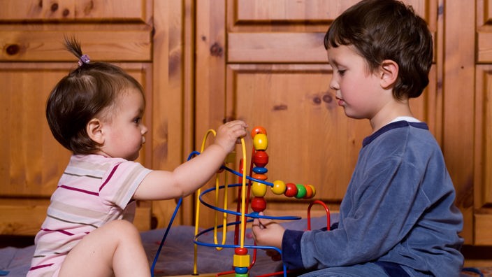 Ein Vierjähriger spielt mit einem einjährigen Mädchen