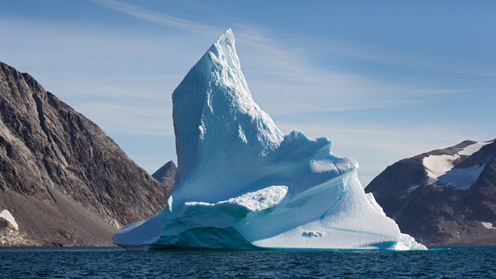 Ein strahlend weißer Eisberggipfel ragt aus dem dunklen Eismeer. | Bildquelle: imago/Dieter Mendzigall Ein strahlend weißer Eisberggipfel ragt aus dem dunklen Eismeer.