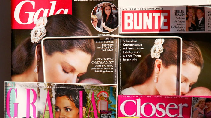Frauenzeitschriften stehen in einem Zeitungsständer an einem Kiosk.