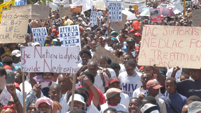 Protestzug von mehr als 10.000 Demonstranten im Februar 2003 in Kapstadt. Auf den Schildern stehen Slogans wie 'Stop AIDS' und 'Aids Treatment now'.