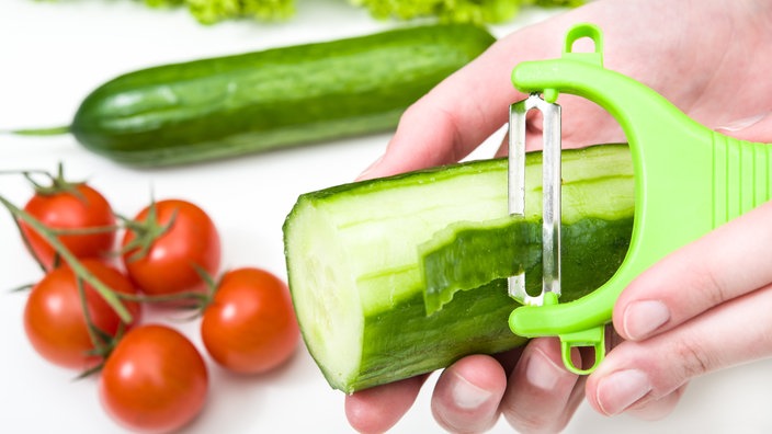 Frau schält eine Gurke, daneben liegen Tomaten und Salat | Bildquelle: dpa/David Ebener Frau schält eine Gurke, daneben liegen Tomaten und Salat