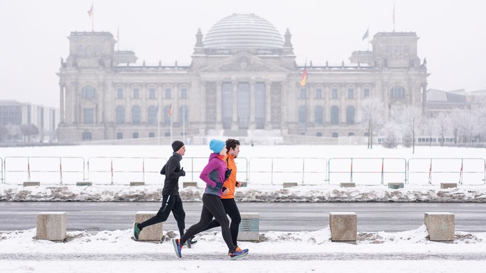 Drei Jogger vor dem Berliner Reichstagsgebäude | Bildquelle: Hans Christian Plambeck/laif Drei Jogger vor dem Berliner Reichstagsgebäude