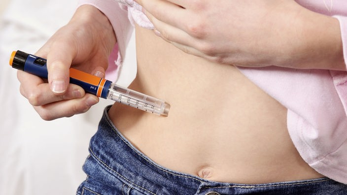 Person spritzt sich Insulin in den Bauch.