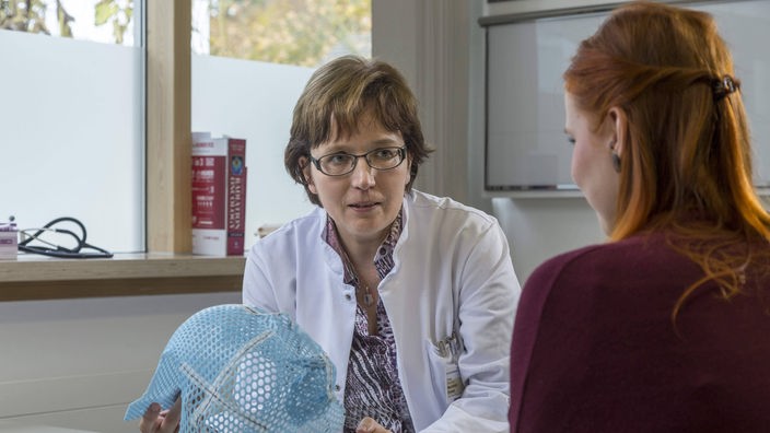 Eine Ärztin spricht im Sprechzimmer mit einer Patientin
