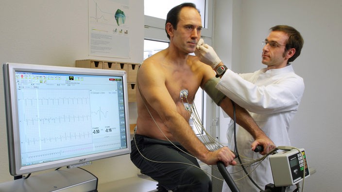 Mann auf Ergometer beim Belastungs-EKG.