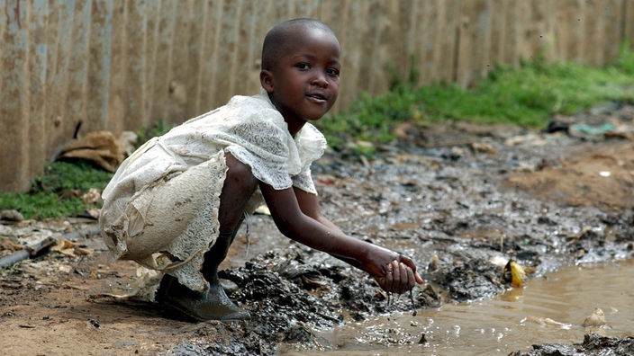 Kind an einer Pfütze in Afrika.