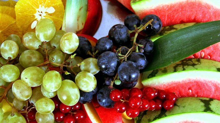 Weintrauben, Wassermelone, geschälte Orangen und Apfelspalten auf einem Obstteller