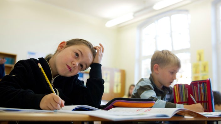 Ein Mädchen und ein Junge sitzen an ihrem Tisch im Klassenzimmer