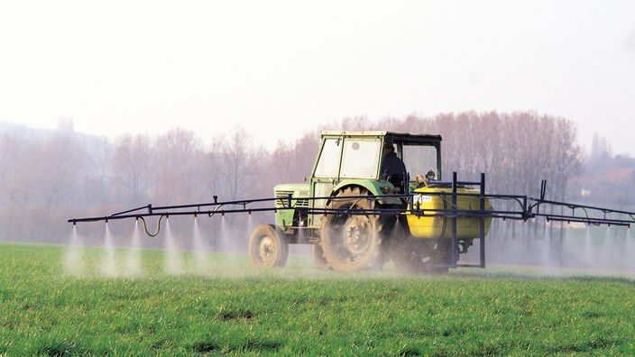 Ein Traktor sprüht Glyphosat auf ein Feld.