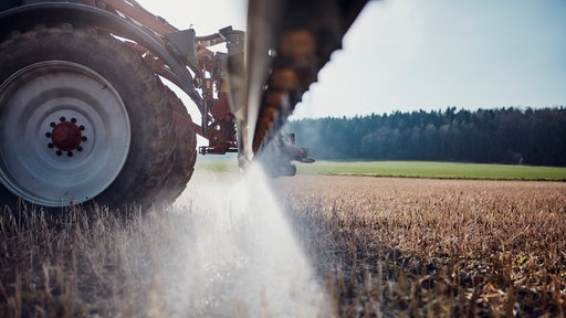 Nahaufnahme Traktor sprüht Glyphosat auf einem Feld.