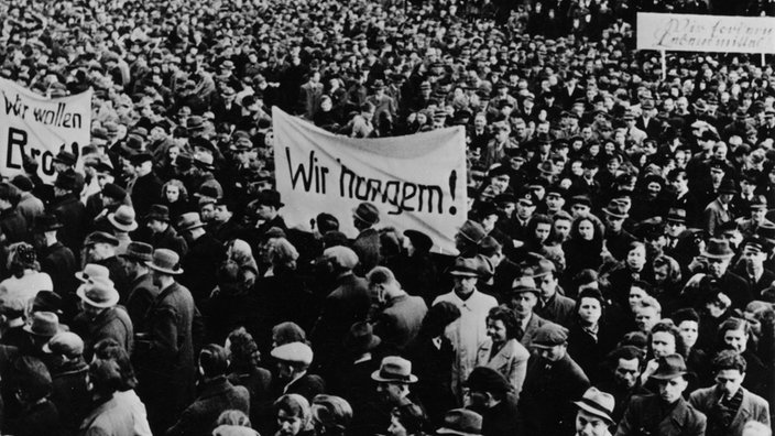 Schwarzweißfoto: Hungerdemonstration von Arbeitern auf dem Karlsplatz in Krefeld (April 1947). | Bildquelle: akg-images Schwarzweißfoto: Hungerdemonstration von Arbeitern auf dem Karlsplatz in Krefeld (April 1947).