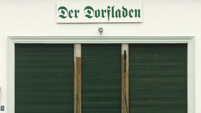 Blick auf einen geschlossenen Laden über dessen Eingangstür ein Schriftzug 'Der Dorfladen' prangt. | Bildquelle: dpa/Jens Wolf Blick auf einen geschlossenen Laden über dessen Eingangstür ein Schriftzug 'Der Dorfladen' prangt.