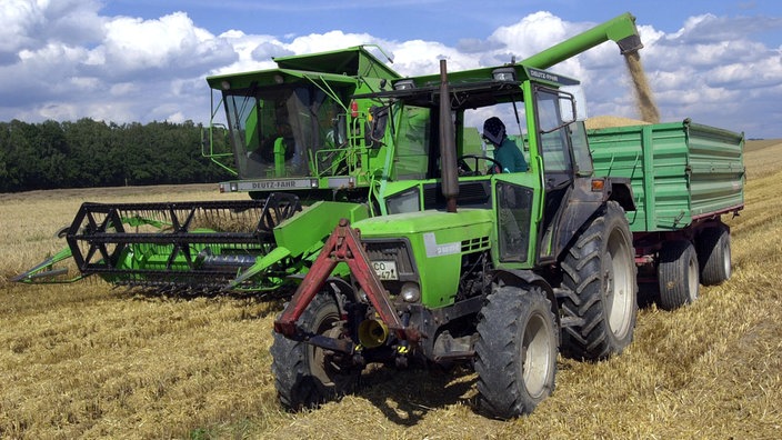 Mähdrescher und Traktor bringen die Wintergerstenernte auf einem Feld in Thüringen ein. | Bildquelle: WDR/ZB/Stefan Thomas Mähdrescher und Traktor bringen die Wintergerstenernte auf einem Feld in Thüringen ein.