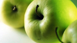 Nahaufnahme von drei gleich großen hellgrünen Äpfeln mit Stiel.