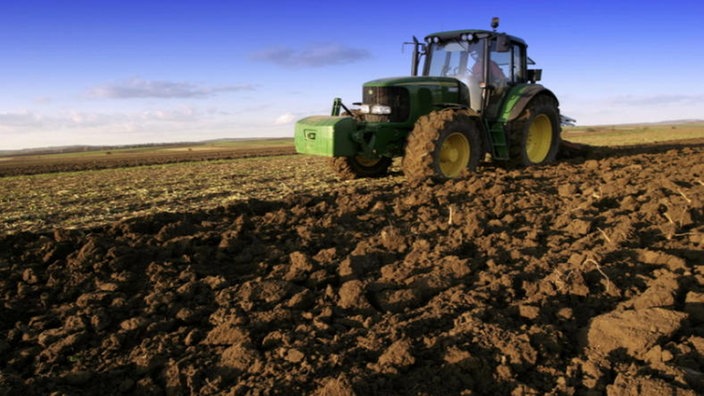 Landwirt pflügt Acker mit einem Traktor um. | Bildquelle: newspixx vario images/Alfred Schauhuber Landwirt pflügt Acker mit einem Traktor um.