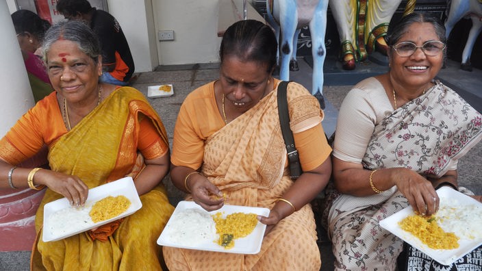 Dre Frauen in Singapur essen Reis