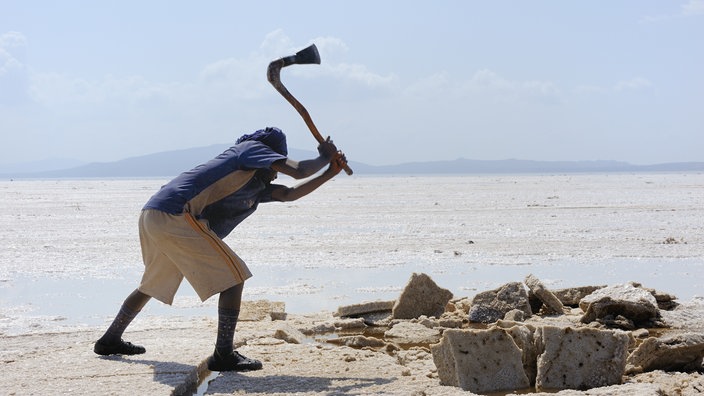 Ein Afar-Nomade, der auf dem Salzsee das weiße Gold abbaut. | Bildquelle: mauritius images Ein Afar-Nomade, der auf dem Salzsee das weiße Gold abbaut.