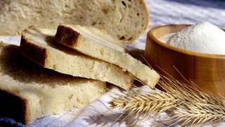 Aufgeschnittenes Brot und Salz nebeneinander.