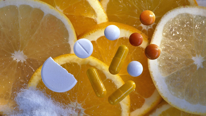 Zitrusfrüchte und Vitamin C-Tabletten.