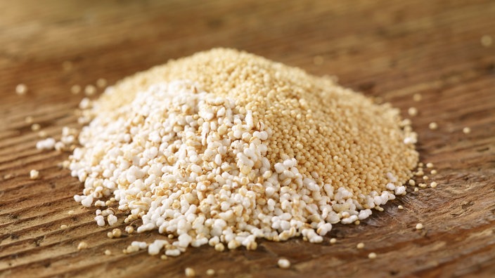 Ein Haufen Amaranth, teilweise gepufft, auf Holzuntergrund. | Bildquelle: mauritius images Ein Haufen Amaranth, teilweise gepufft, auf Holzuntergrund.