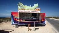 Der Imbissstand mit der Aufschrift "Letzte Bratwurst vor Amerika" an der Westküste der Algarve in Portugal.