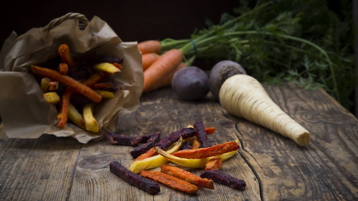 Frisches und frittiertes Gemüse; Möhren, Pastinaken und Rote Bete auf einem Tisch