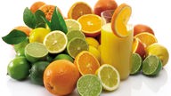 Zitrusfrüchte und ein Glas Orangensaft
