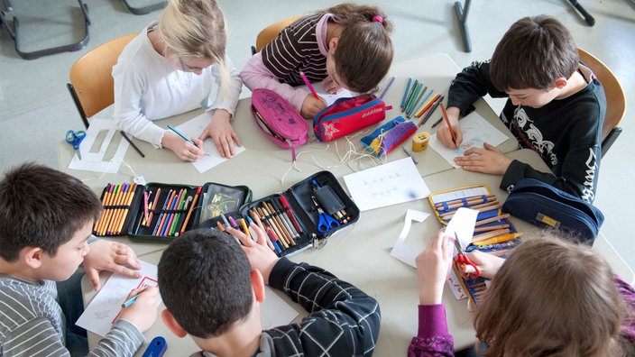 Sechs Kinder malen an einem Tisch | Bildquelle: picture alliance / Uwe Anspach Sechs Kinder malen an einem Tisch