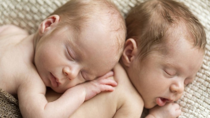 Neugeborene Zwillinge schlafen auf einem Handtuch