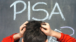 Ein Junge steht vor einer Tafel mit der Aufschrift 'PISA' und rauft sich die Haare.