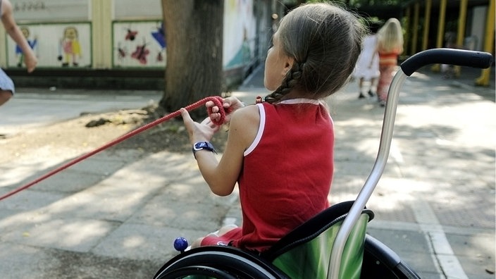 Zwei Mädchen auf dem Schulhof, eines sitzt im Rollstuhl. | Bildquelle: ddp images/dapd/Thomas Lohnes Zwei Mädchen auf dem Schulhof, eines sitzt im Rollstuhl.