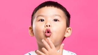 Asiatischer Junge formt mit dem Mund ein O