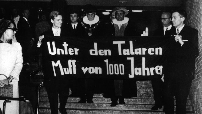 Studenten mit einem Spruchband: Unter den Talaren Muff von 1000 Jahren beim Eintritt des neuen und des alten Rektors der Universität Hamburg ins Auditorium Maximum.