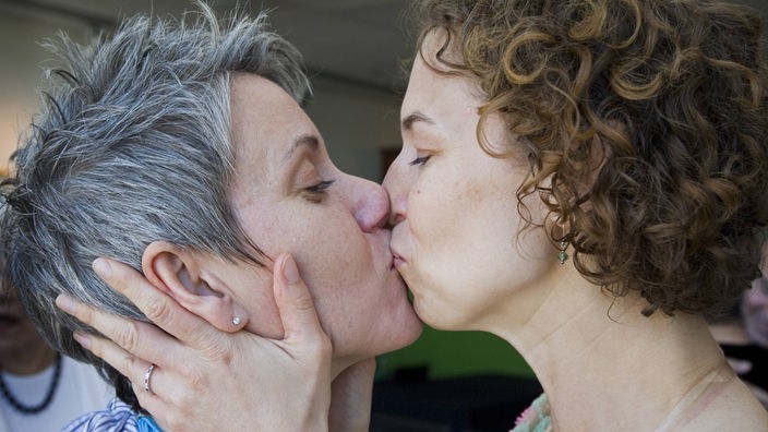 Zwei Frauen küssen sich.