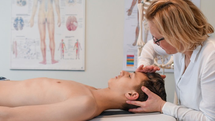 Eine Osteopathin behandelt einen jungen Mann durch Berührungen am Kopf | Bildquelle: picture alliance / Patrick Pleul/dpa-Zentralbild/ZB Eine Osteopathin behandelt einen jungen Mann durch Berührungen am Kopf