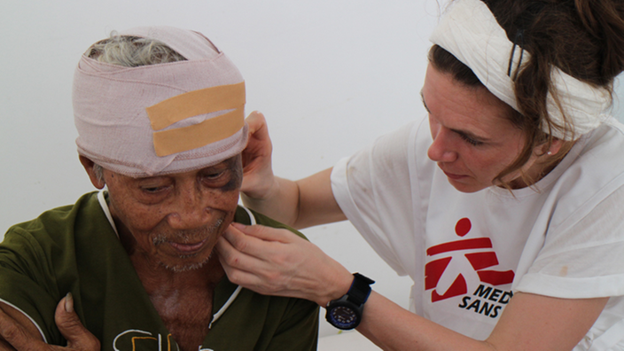 Eine Ärztin verbindet einem verletzten Mann den Kopf. | Bildquelle: Caroline Van Nespen/MSF Eine Ärztin verbindet einem verletzten Mann den Kopf.