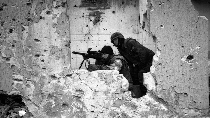 Zwei Soldaten mit Maschinengewehr in einer Ruine.