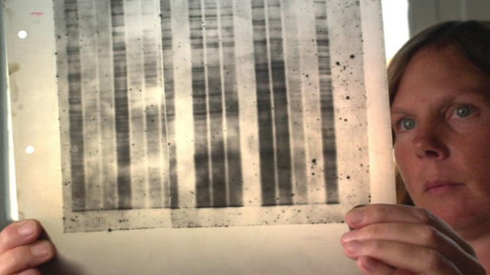 Eine Frau betrachtet einen DNA-Test.