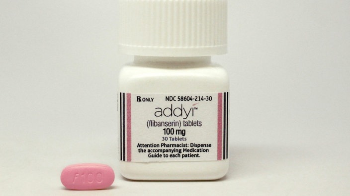 Eine pinkfarbene Pille liegt neben einer Dose mit der Aufschrift "addyi". | Bildquelle: dpa/Handoutharmaceuticals/fer10 Eine pinkfarbene Pille liegt neben einer Dose mit der Aufschrift "addyi".