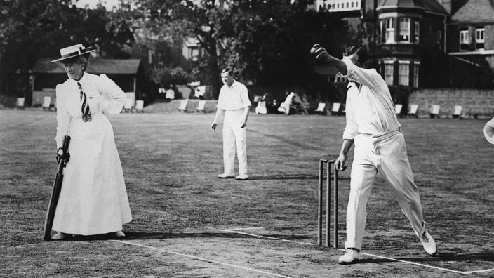 Schwarzweiß-Foto: Mann und Frau beim Kricket-Spiel. | Bildquelle: akg Schwarzweiß-Foto: Mann und Frau beim Kricket-Spiel.